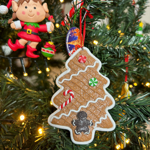 Gingerbread kerstboom hanger van het merk Christmas Paradise. Op de bruine gingerbread kerstboom een zuurstok en candy.