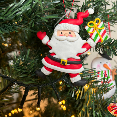 Kerstman met een kerstcadeau in zijn handen voor in de kerstboom. Christmas Paradise