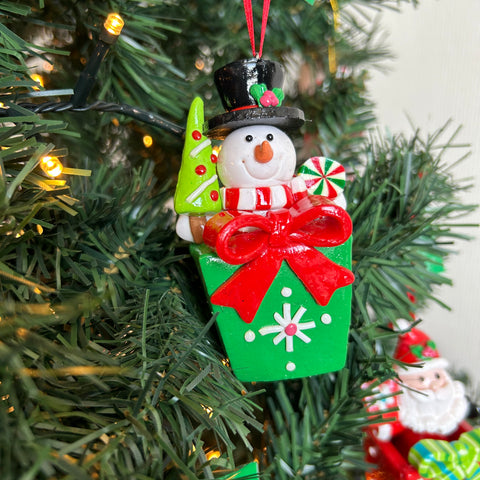 Sneeuwpop uit een cadeau die in de kerstboom hangt